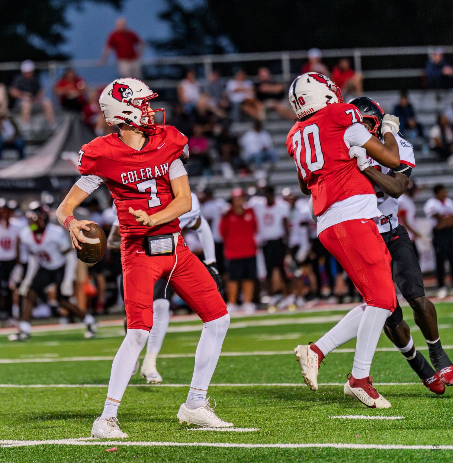 Colerain quarterback drops back to pass wearing red jersey number 1 with offensive lineman number 70 blocking.