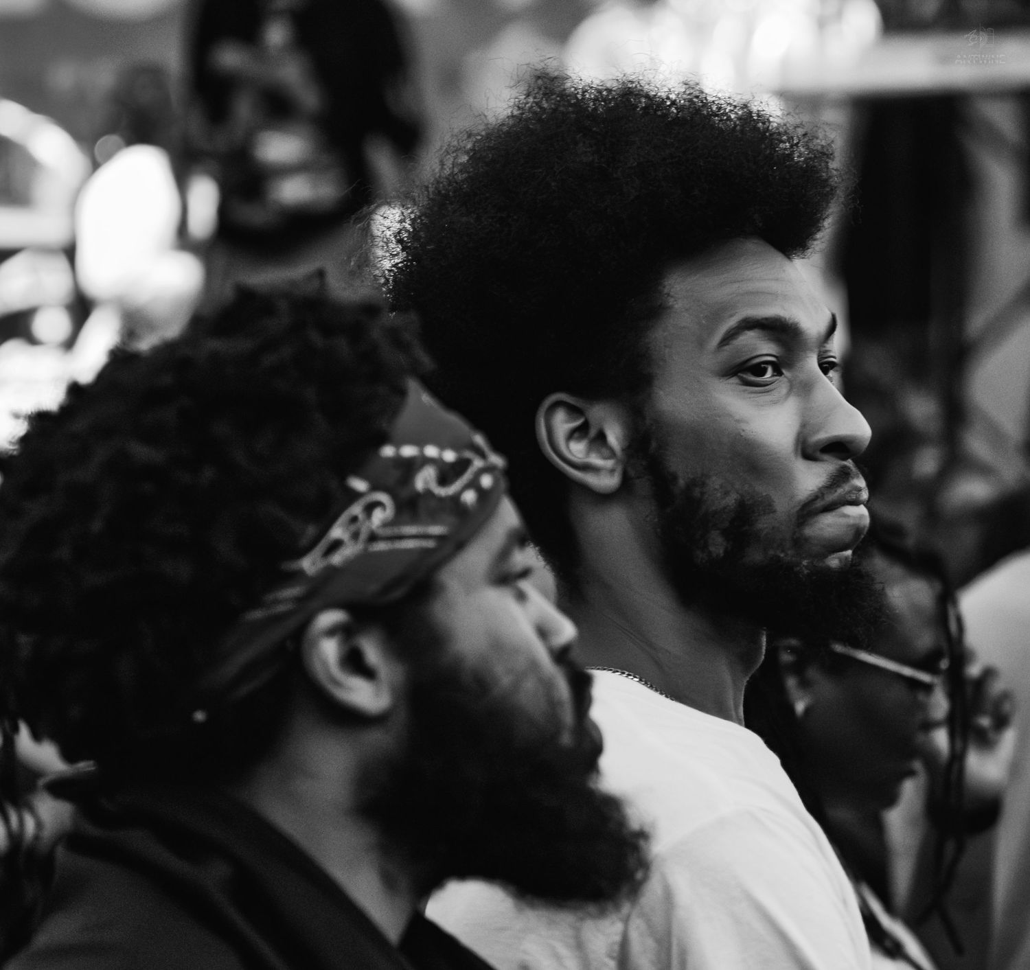 Black and white photo of two young Black men with natural hair and beards, looking intently to the side.