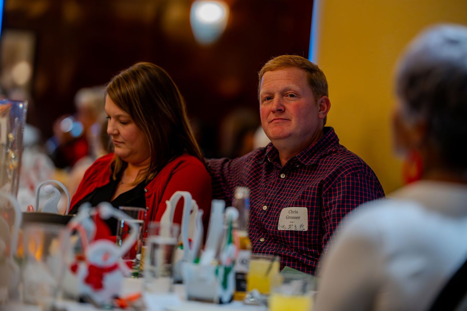 Man and woman seated at a banquet table during a formal dinner event, smiling and engaged in conversation.