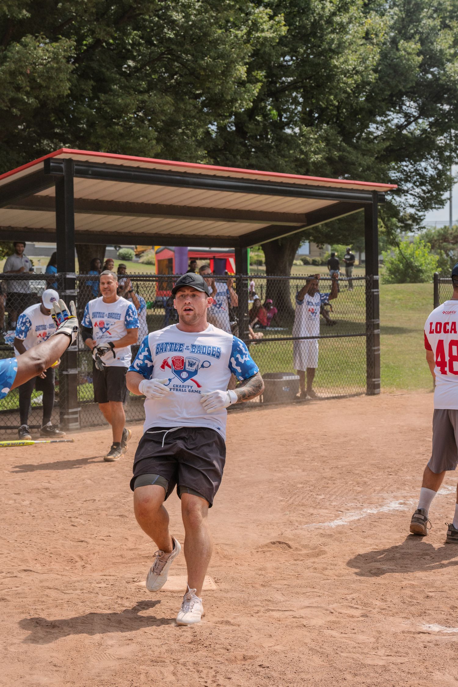 Excited player running bases in softball game wearing Battle 4 Bound jersey.