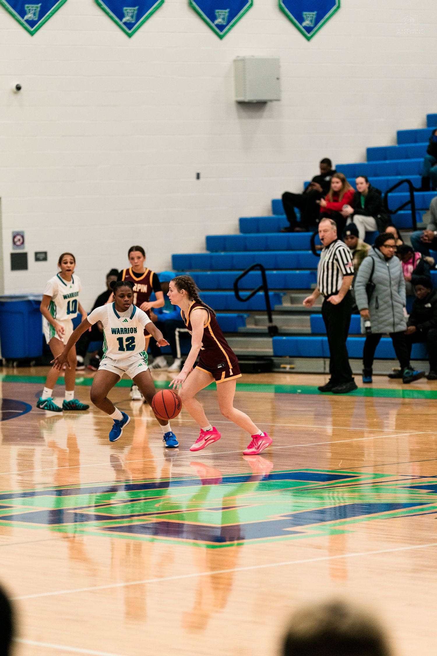 Warriors #12 defends Turpin ball handler during a girls high school basketball game.