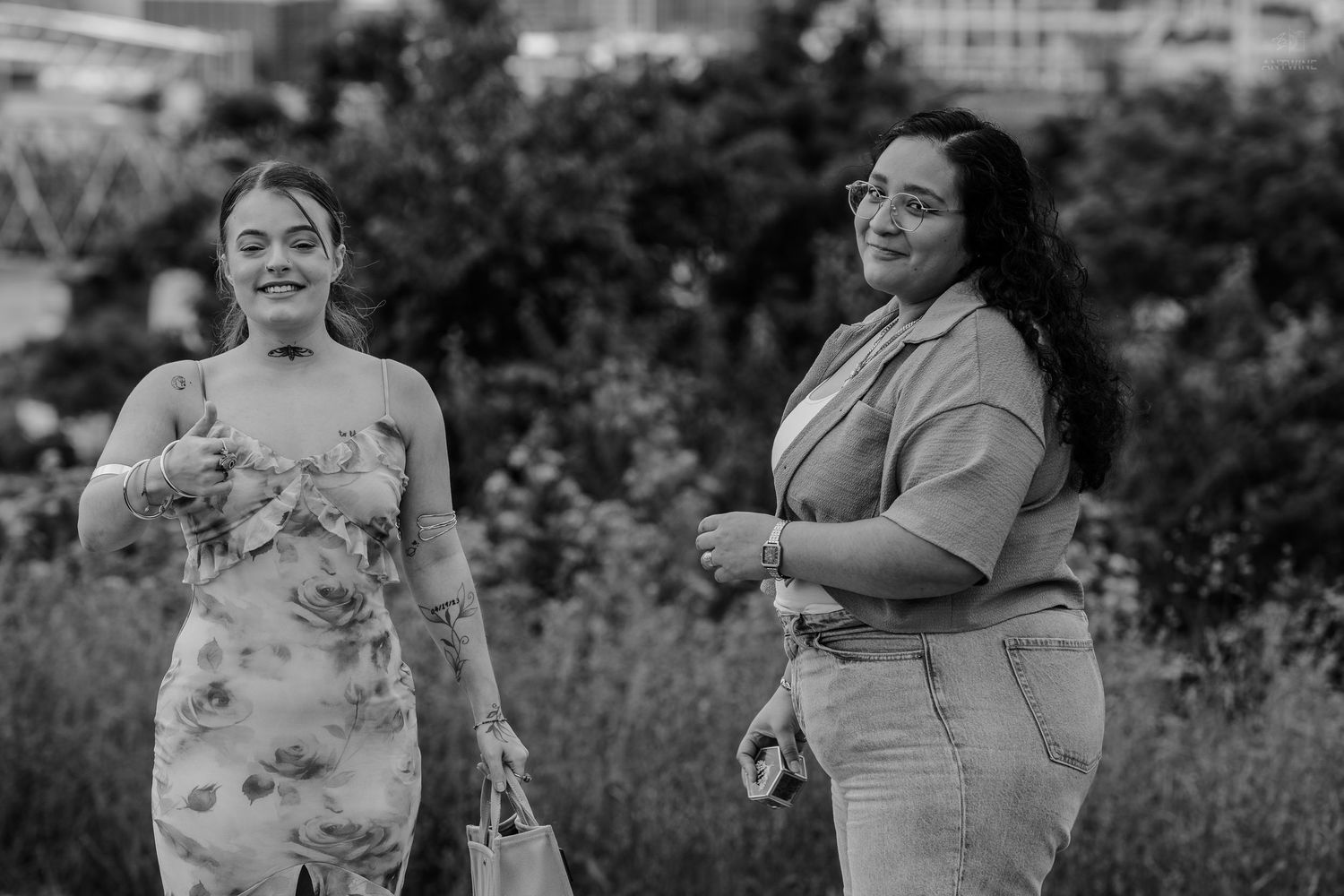 Two happy women walking together outdoors in black and white photography.