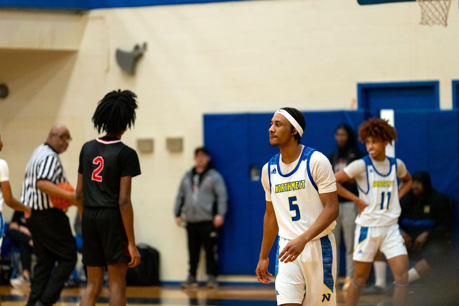Northwestern high school basketball player number 5 stands on the court during a game.