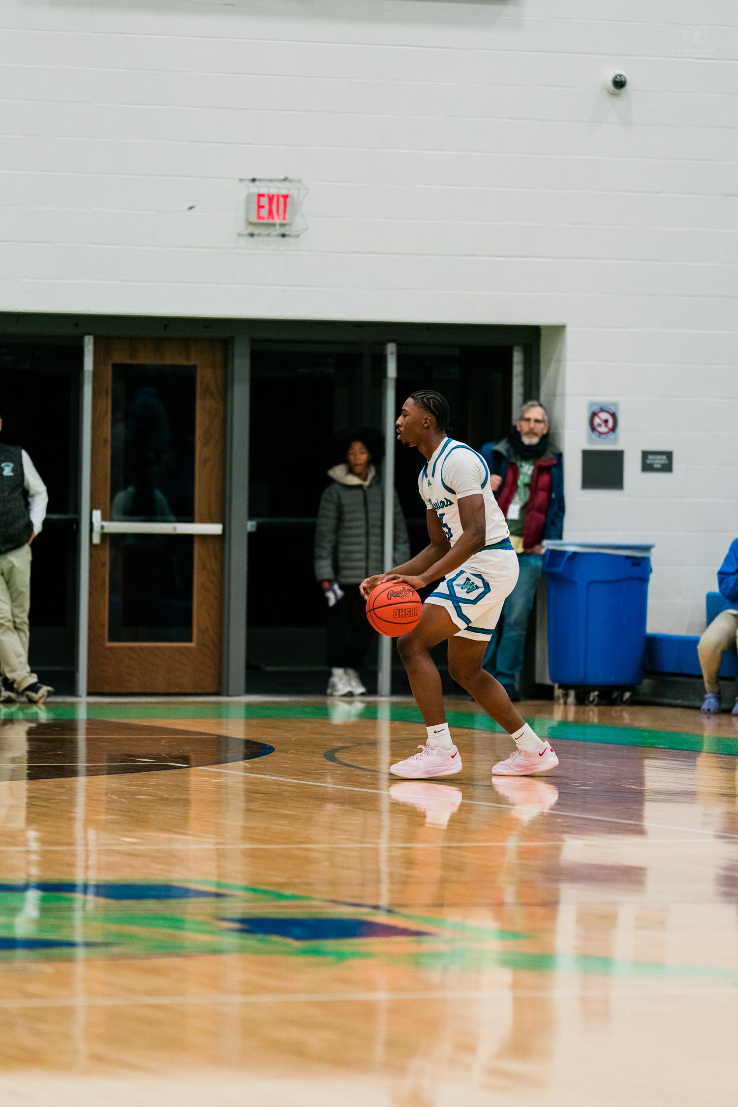 Winton Woods basketball player holds the ball near the three-point line during a high school basketball game.