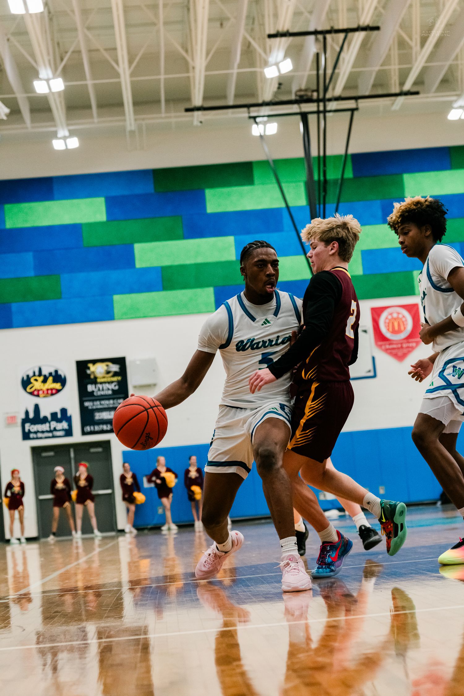 Winton Woods Warriors player dribbles past a Turpin defender during a home high school basketball game.