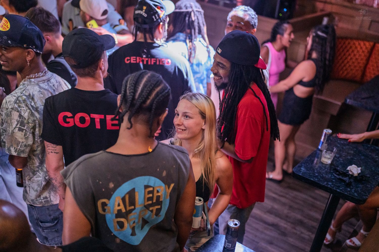 Group of friends chatting and socializing on a vibrant nightclub dance floor.