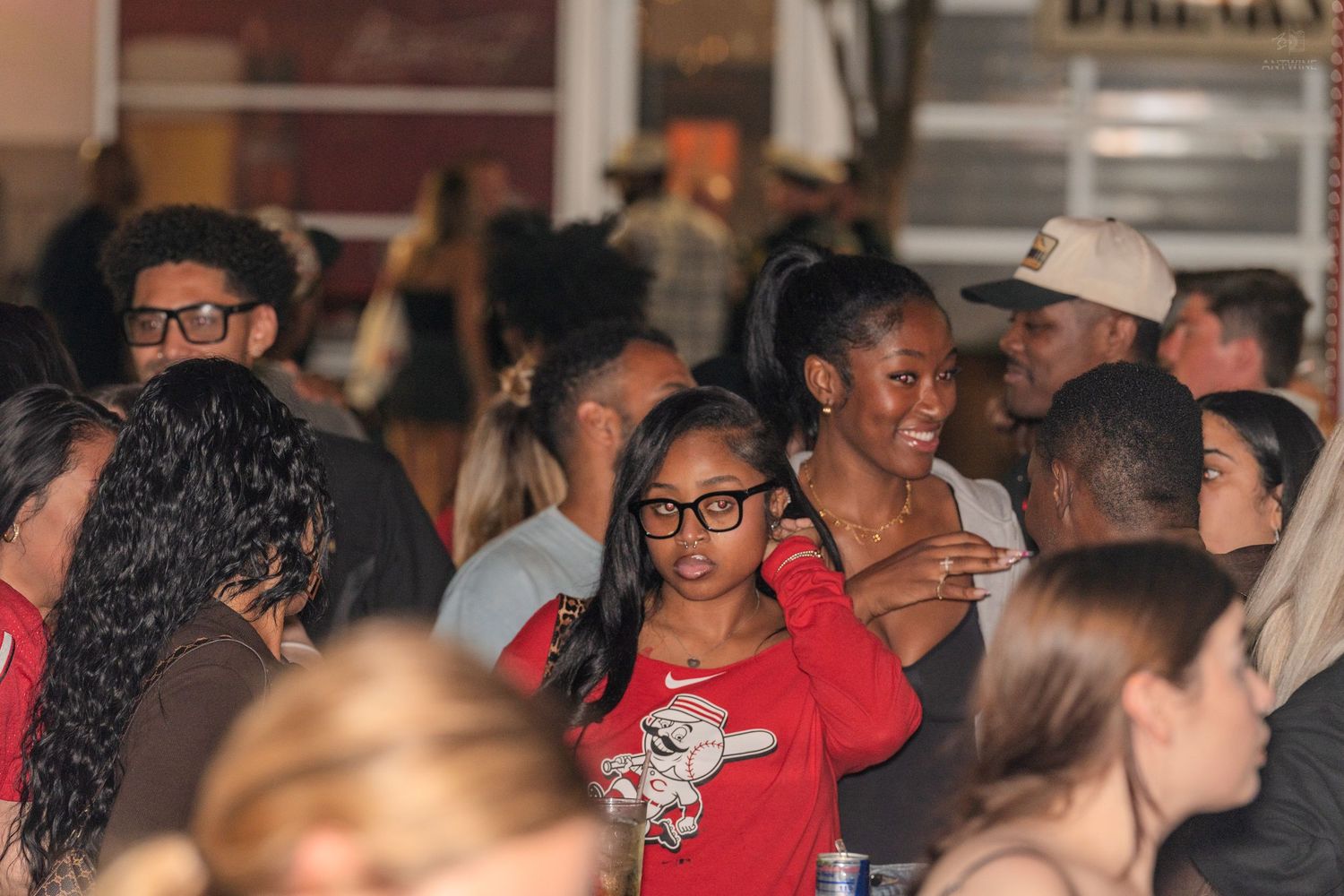 Diverse crowd of people socializing and enjoying a lively indoor party event.