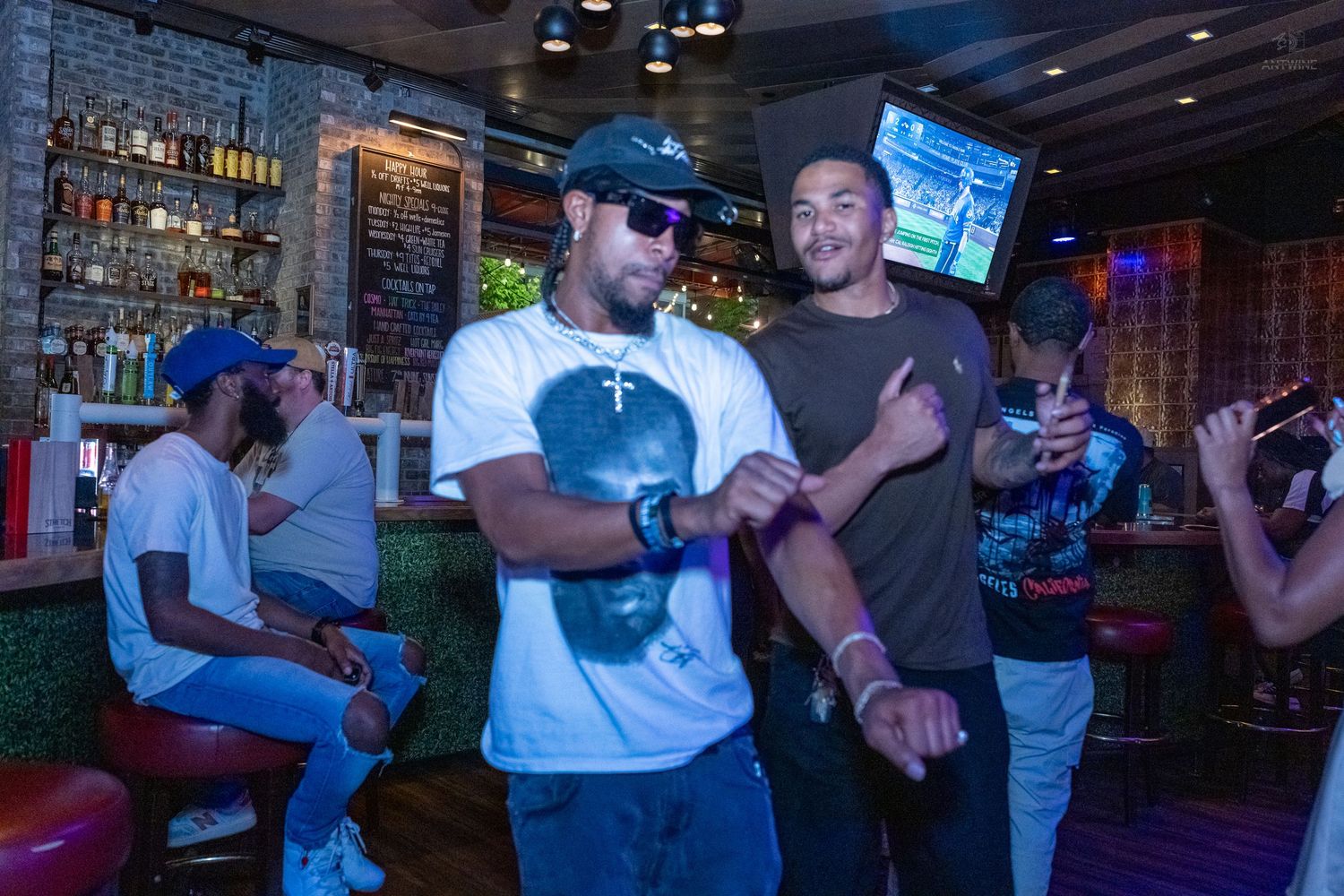 Two men smiling and posing together near the bar at Stretch Bar venue.