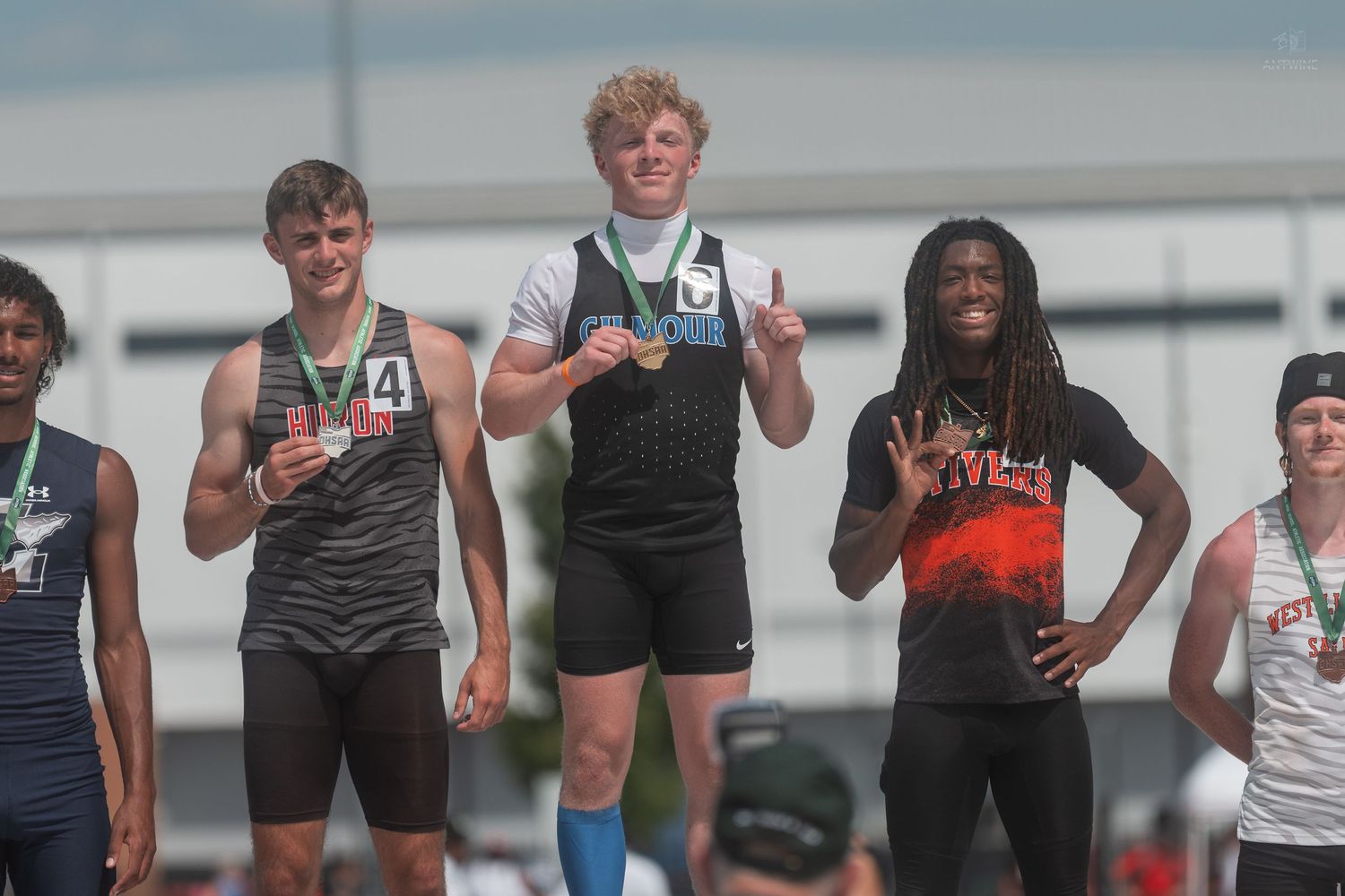 First place high school athlete proudly displays gold medal at OHSAA Division IV track championship podium.