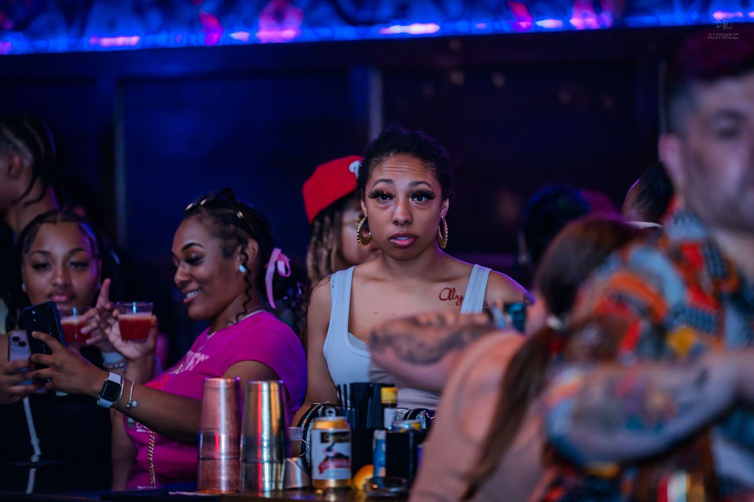Group of friends socializing at a vibrant nightclub bar scene.