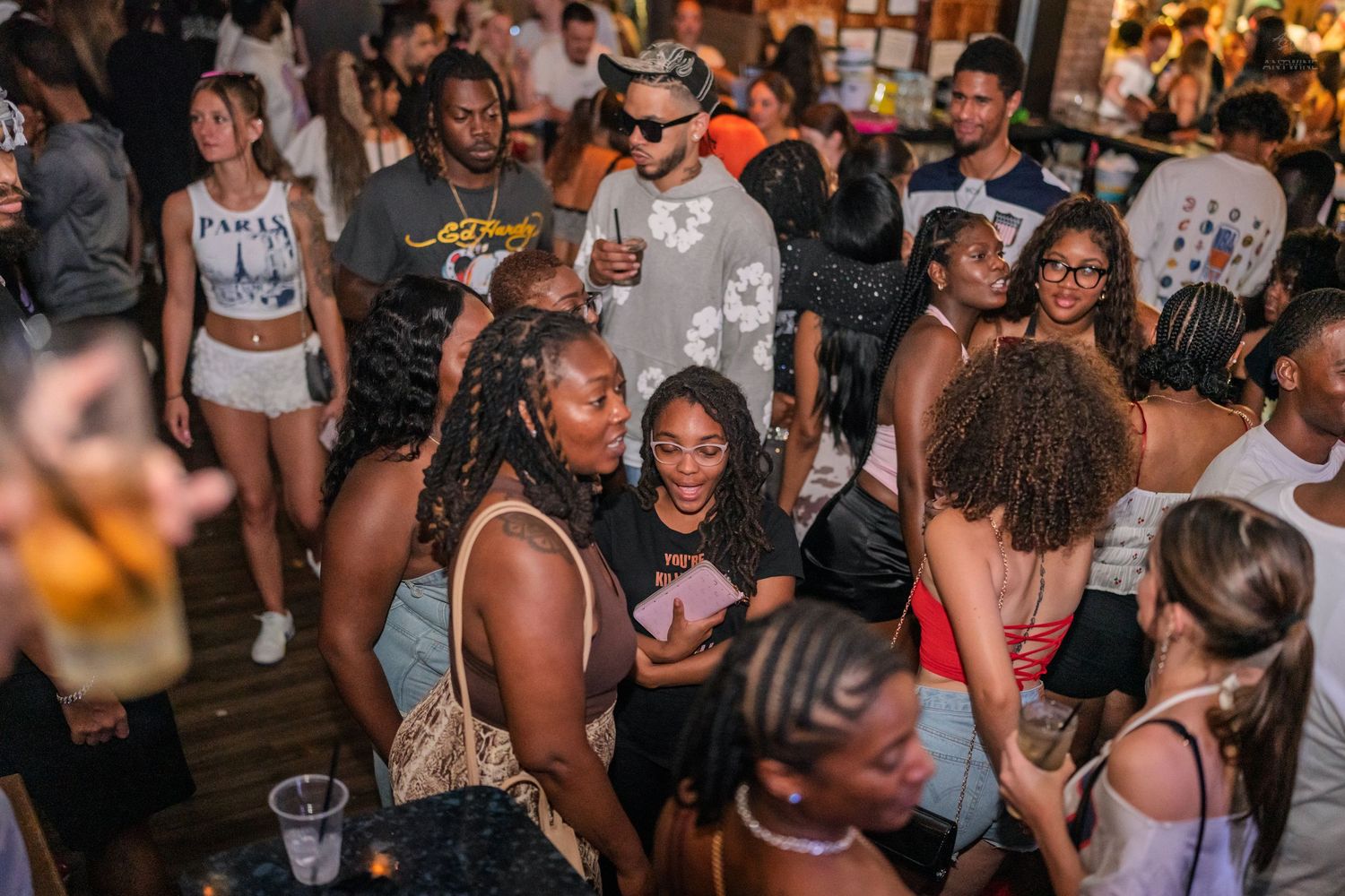 Energetic crowd dancing and socializing at an indoor nightclub party event.