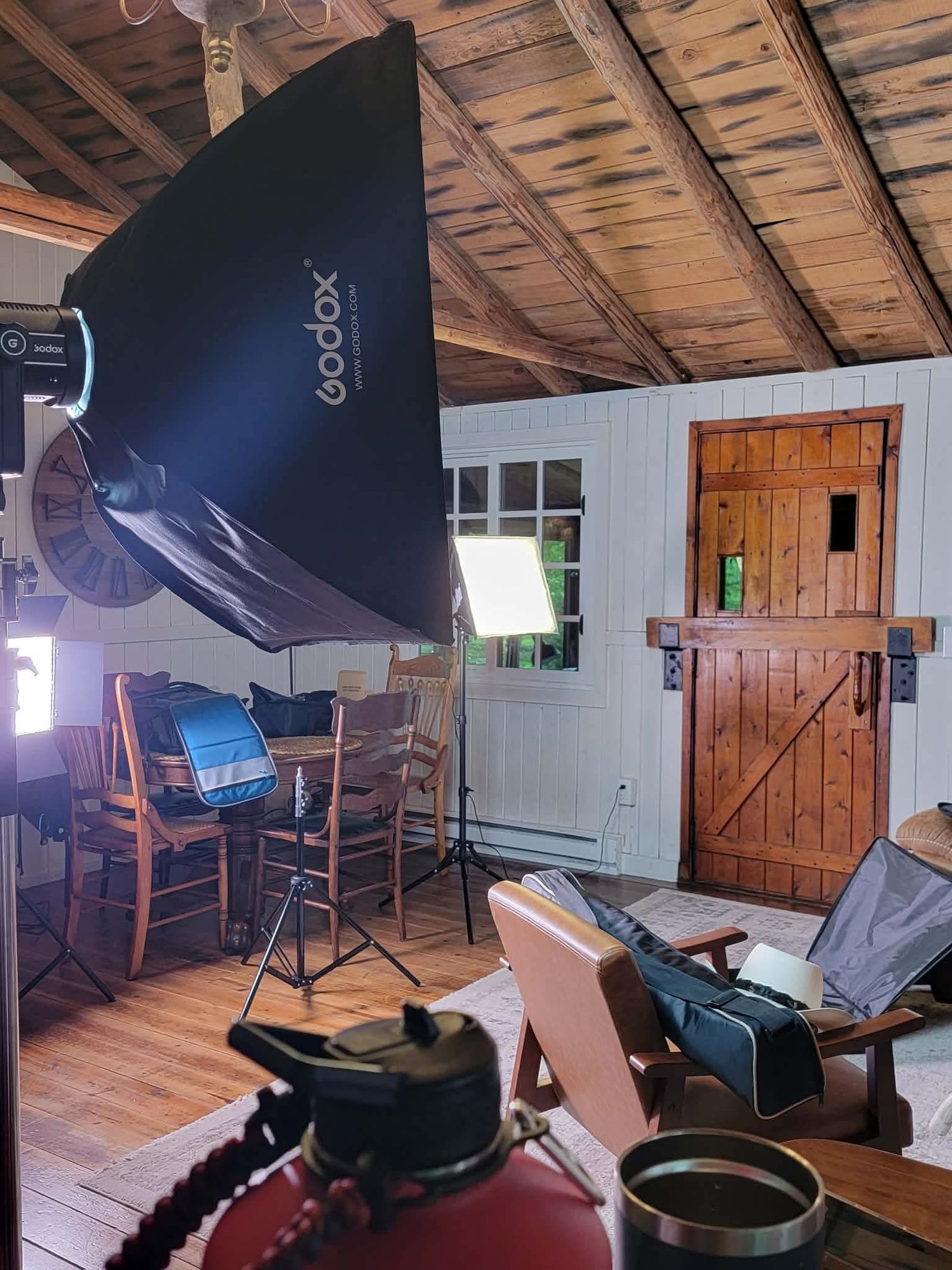 Indoor film studio setup with Godox softbox lighting equipment in rustic cabin.