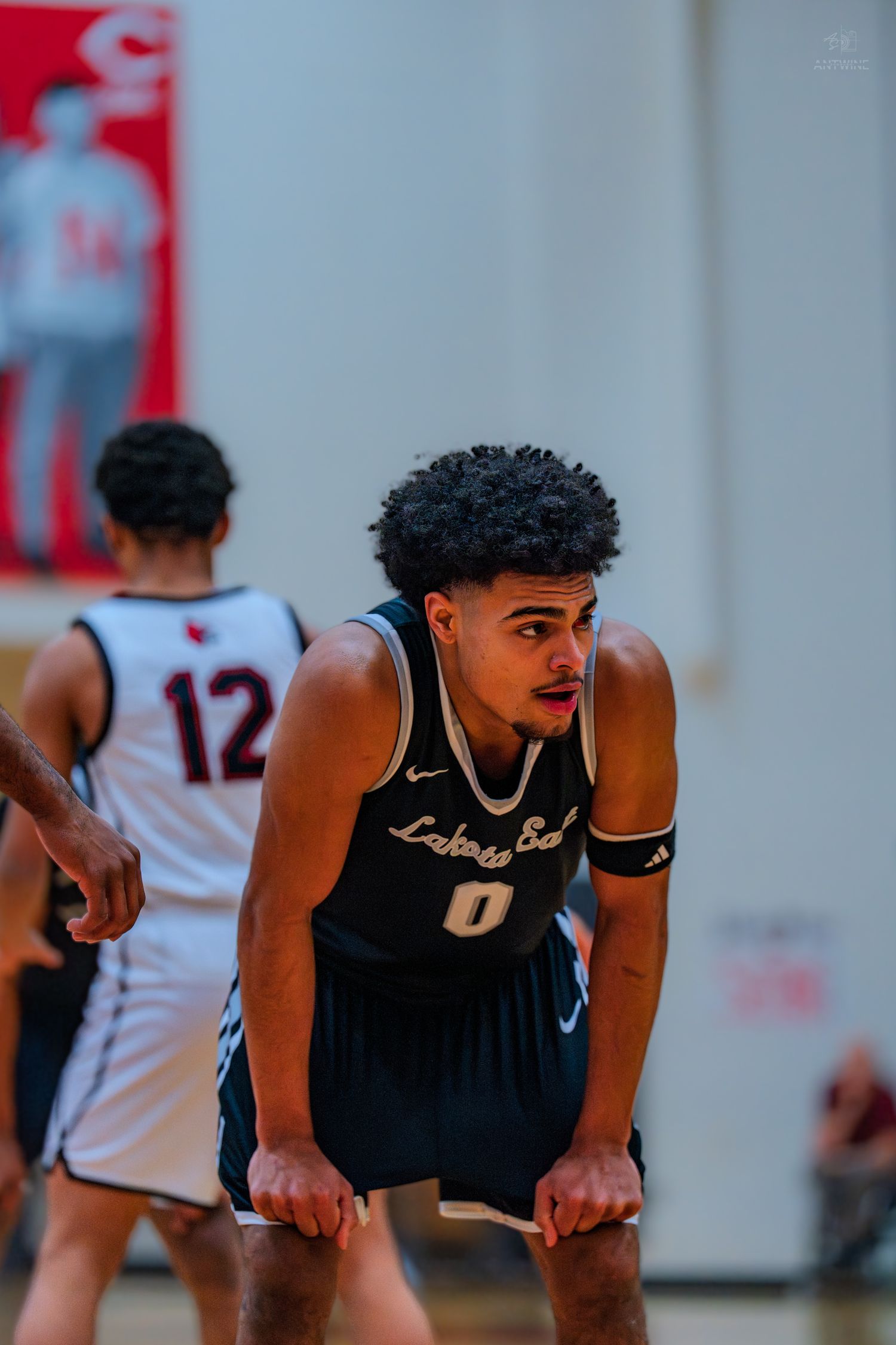 Lakota East basketball player #0 crouches in defensive stance during a high school basketball game.