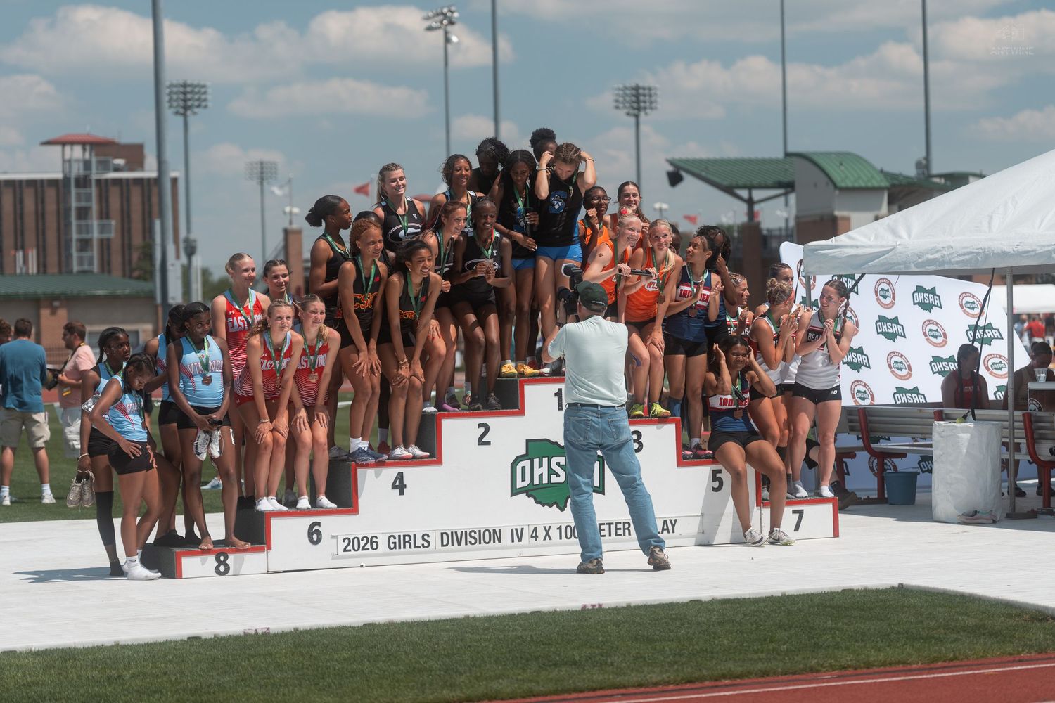 Girls relay teams standing on numbered awards podium at OHSAA Division IV 4x100 Meter Relay meet.