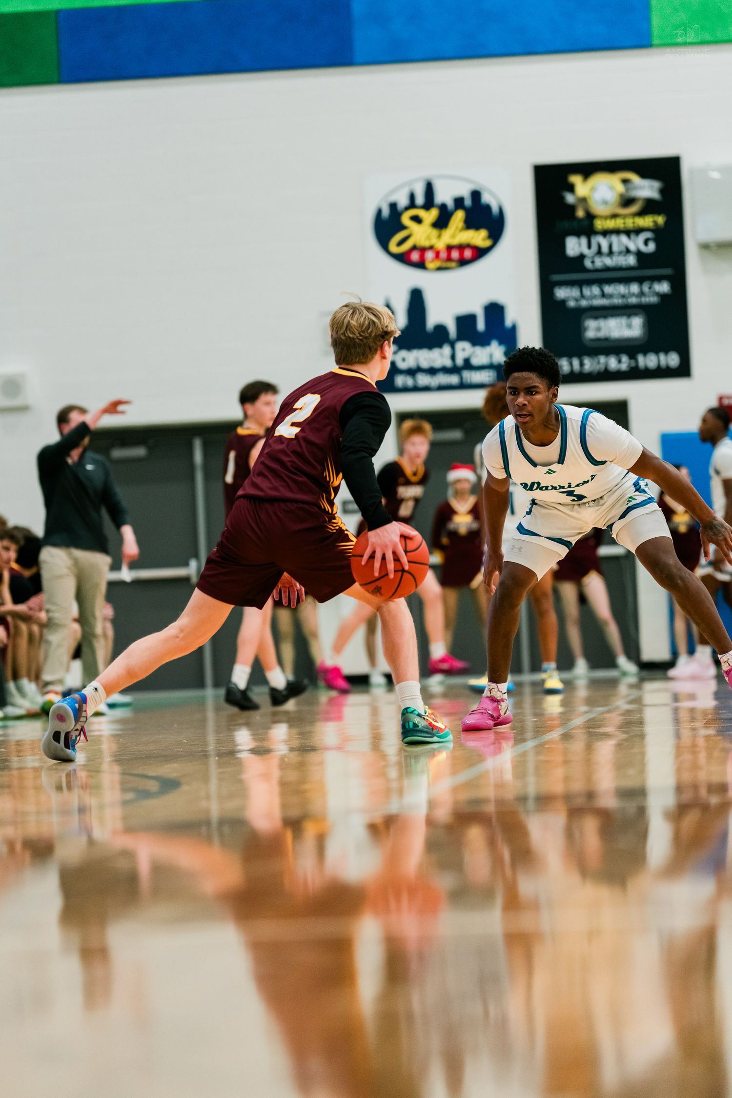 Warriors player in teal uniform guards Turpin #2 dribbling during a high school basketball game.