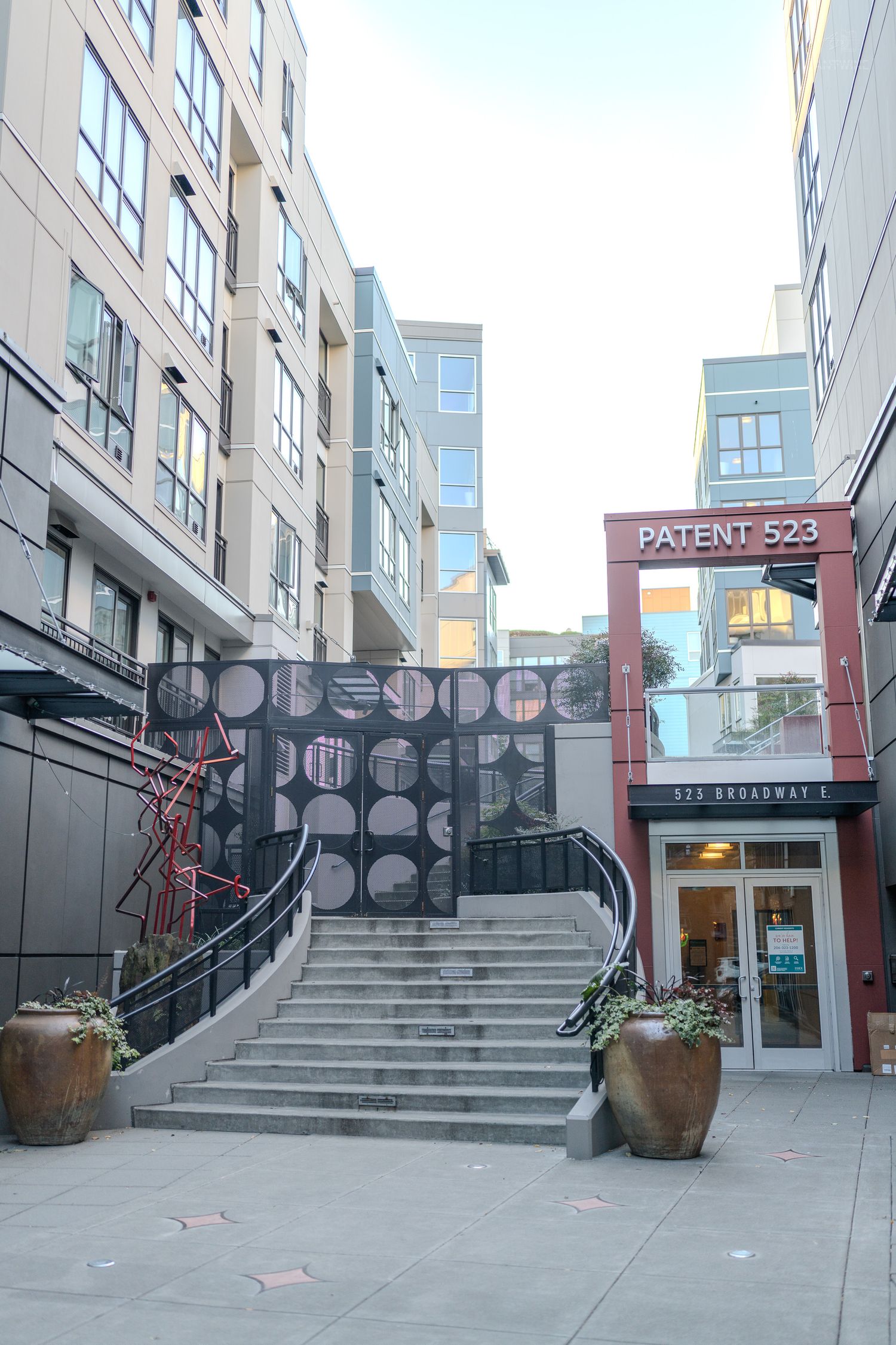 Modern urban courtyard with decorative staircase leading to Patent 523 building entrance at 523 Broadway.