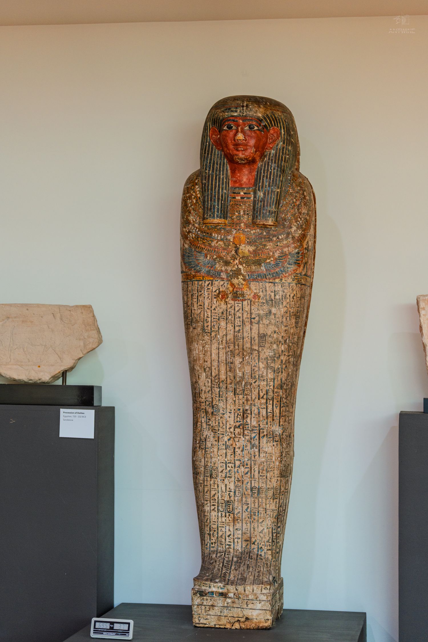 Ancient Egyptian painted wooden sarcophagus with hieroglyphics and colorful face displayed in a museum exhibit.