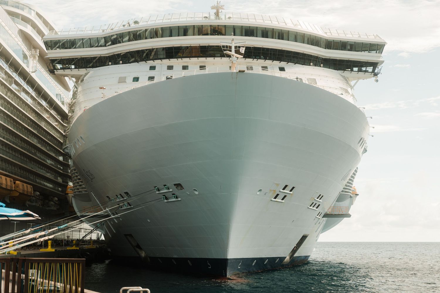 Large cruise ship docked at port viewed from the front bow perspective.