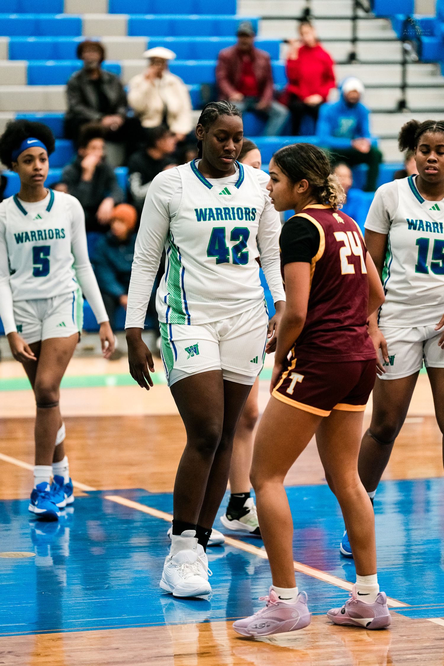 Warriors #42 tall player guards Turpin #24 during a girls high school basketball game.