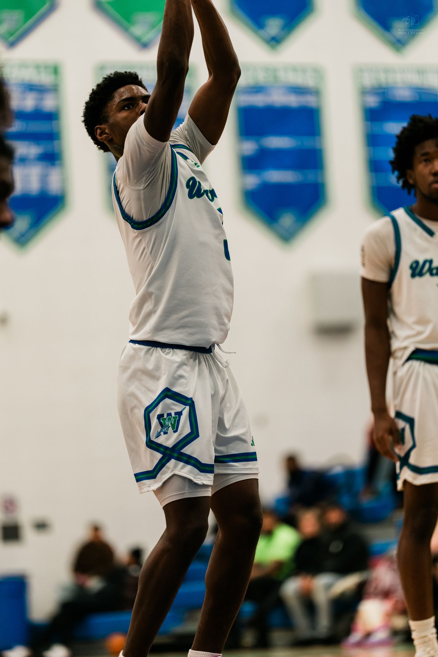Warriors player #3 releases jump shot while teammate watches during basketball game.