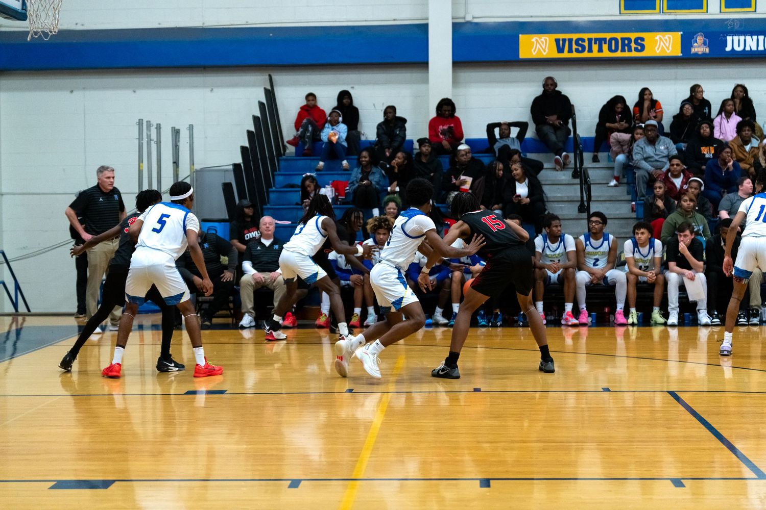 Players battle for position during intense high school basketball game.