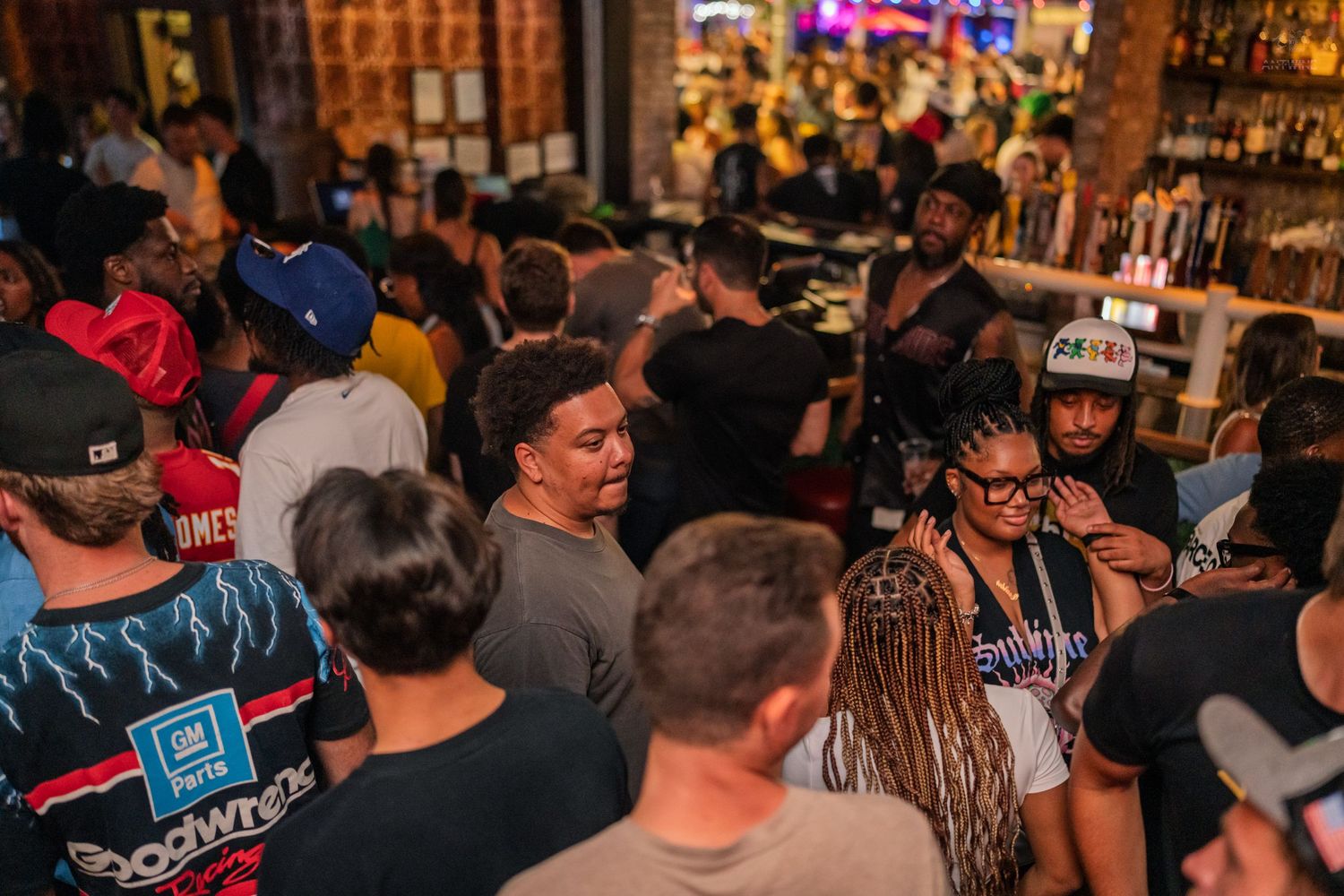 Large diverse crowd packed together enjoying a night out at a popular bar venue.