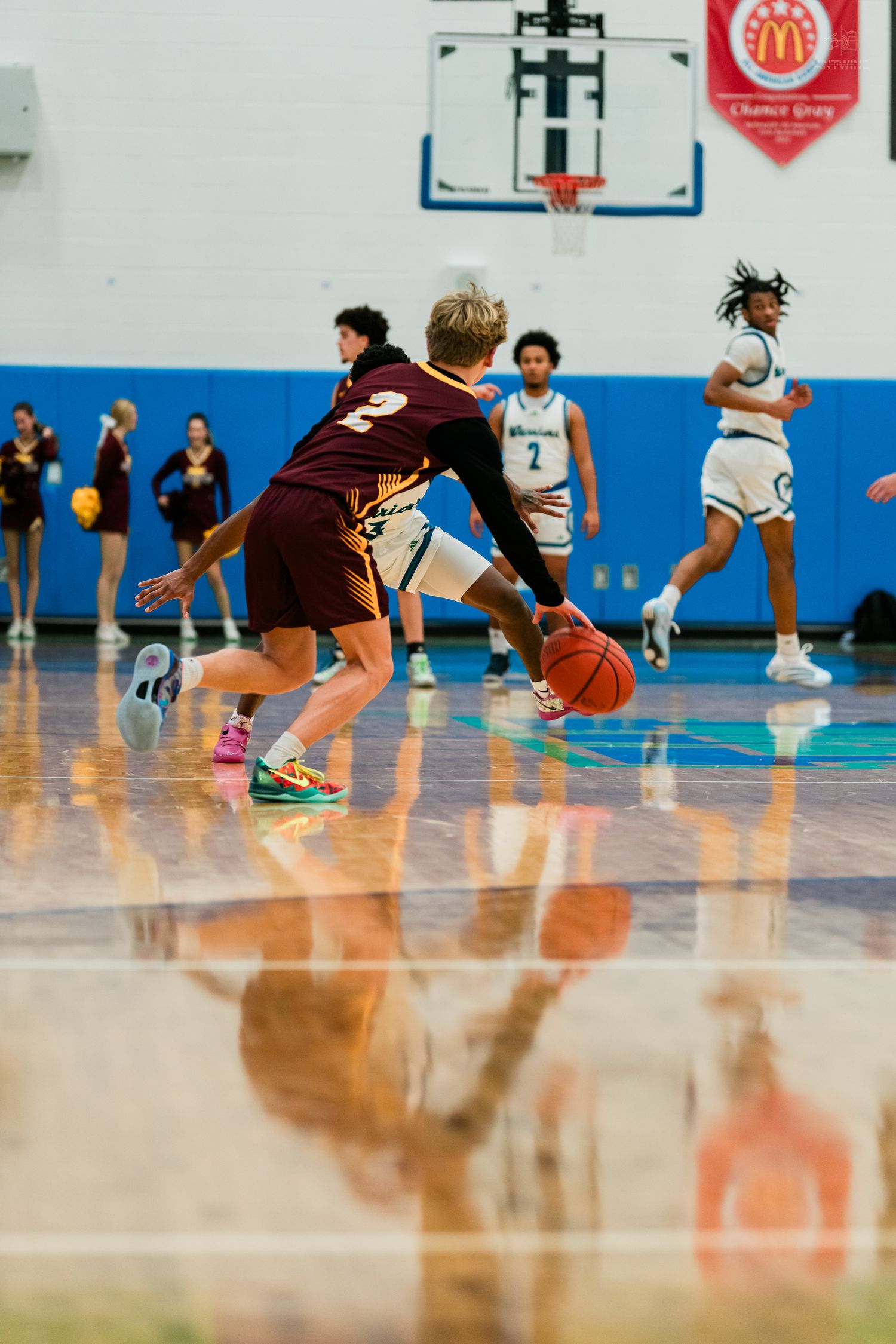 A Turpin player dribbles the ball while a Warriors defender applies pressure during a high school basketball game.