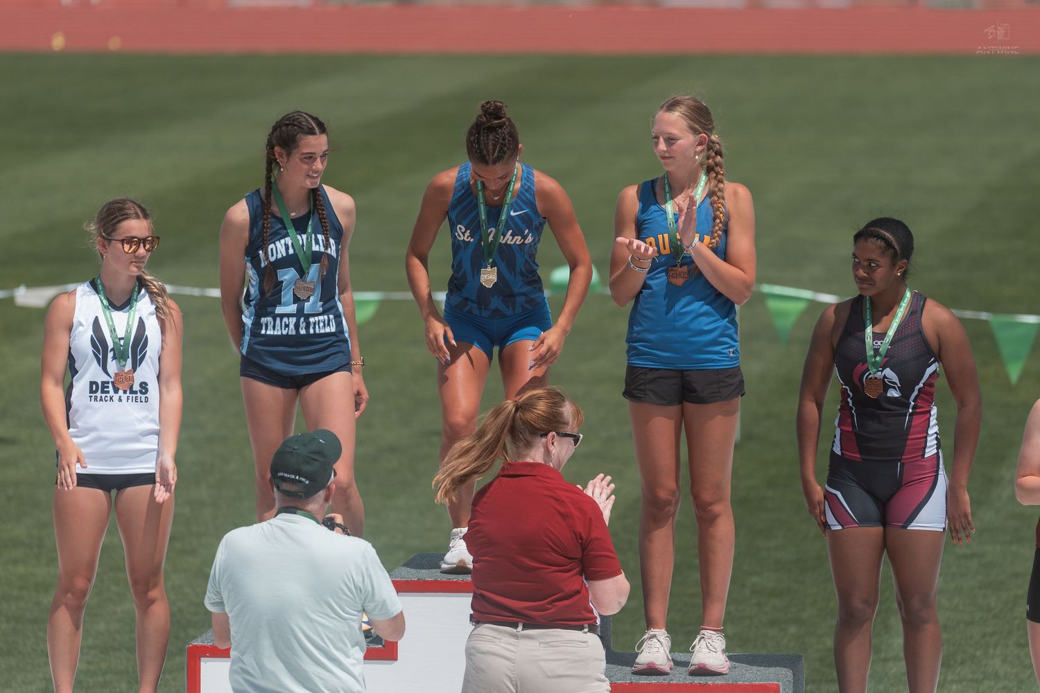 Female athletes gather on awards podium at OHSAA state Division V track and field championship.