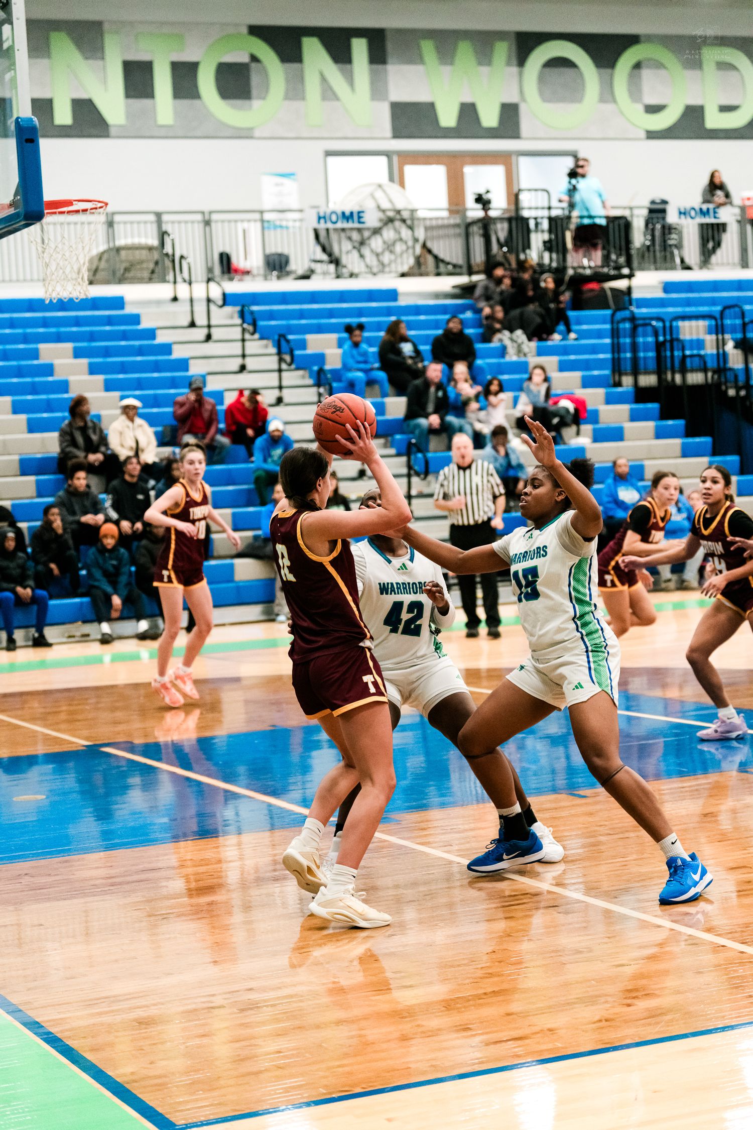 Warriors #42 and #15 defend against a Turpin player driving to the hoop in a girls basketball game.