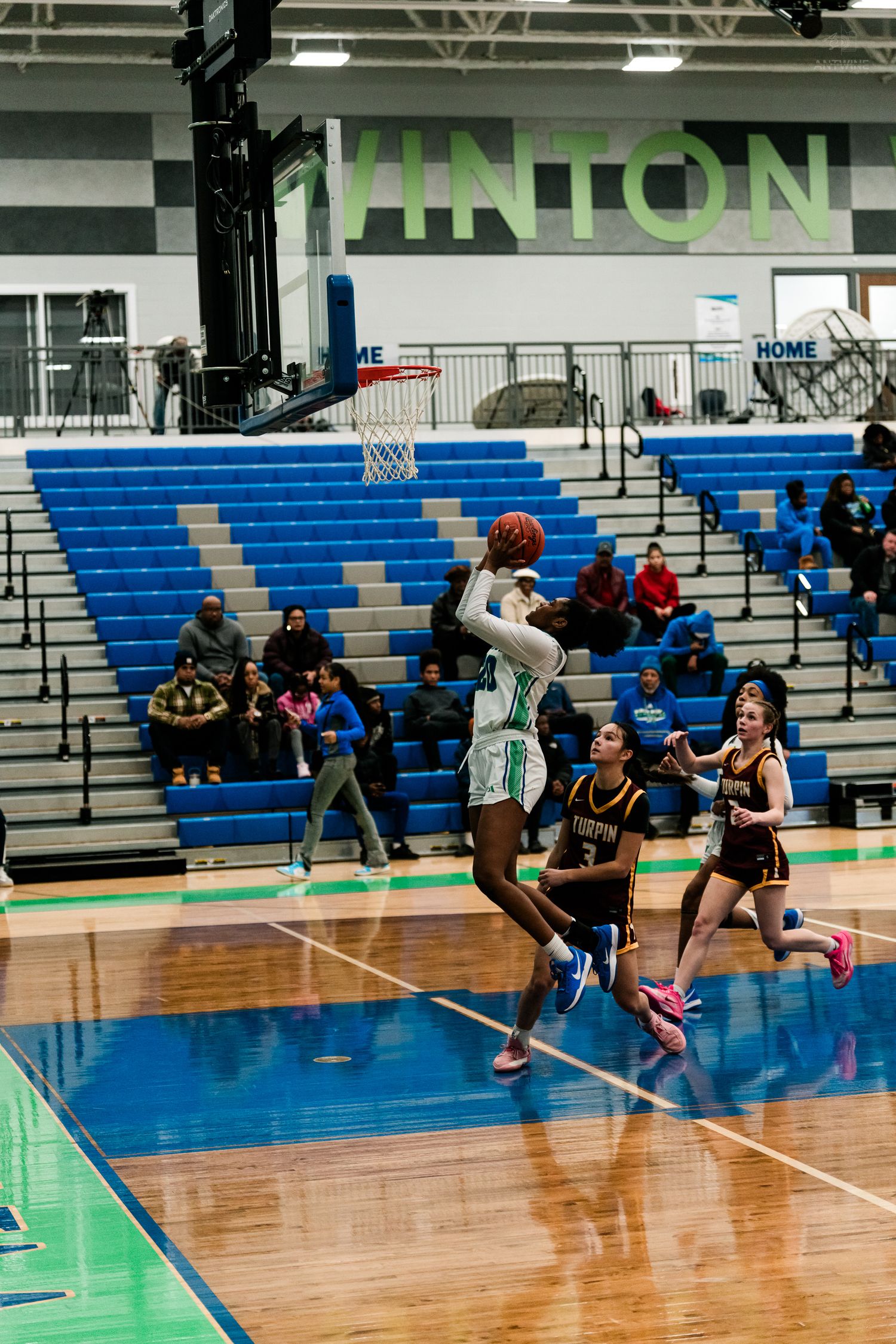 A Warriors player leaps for a layup against Turpin defenders in a girls high school basketball game at Vinton.