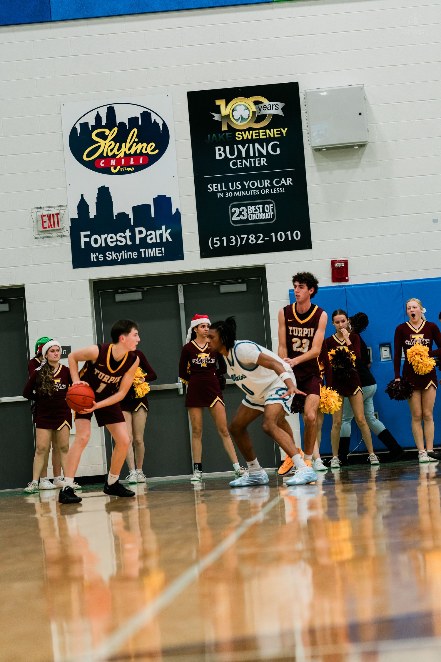 Turpin high school girls basketball players defend near half-court during a competitive game.