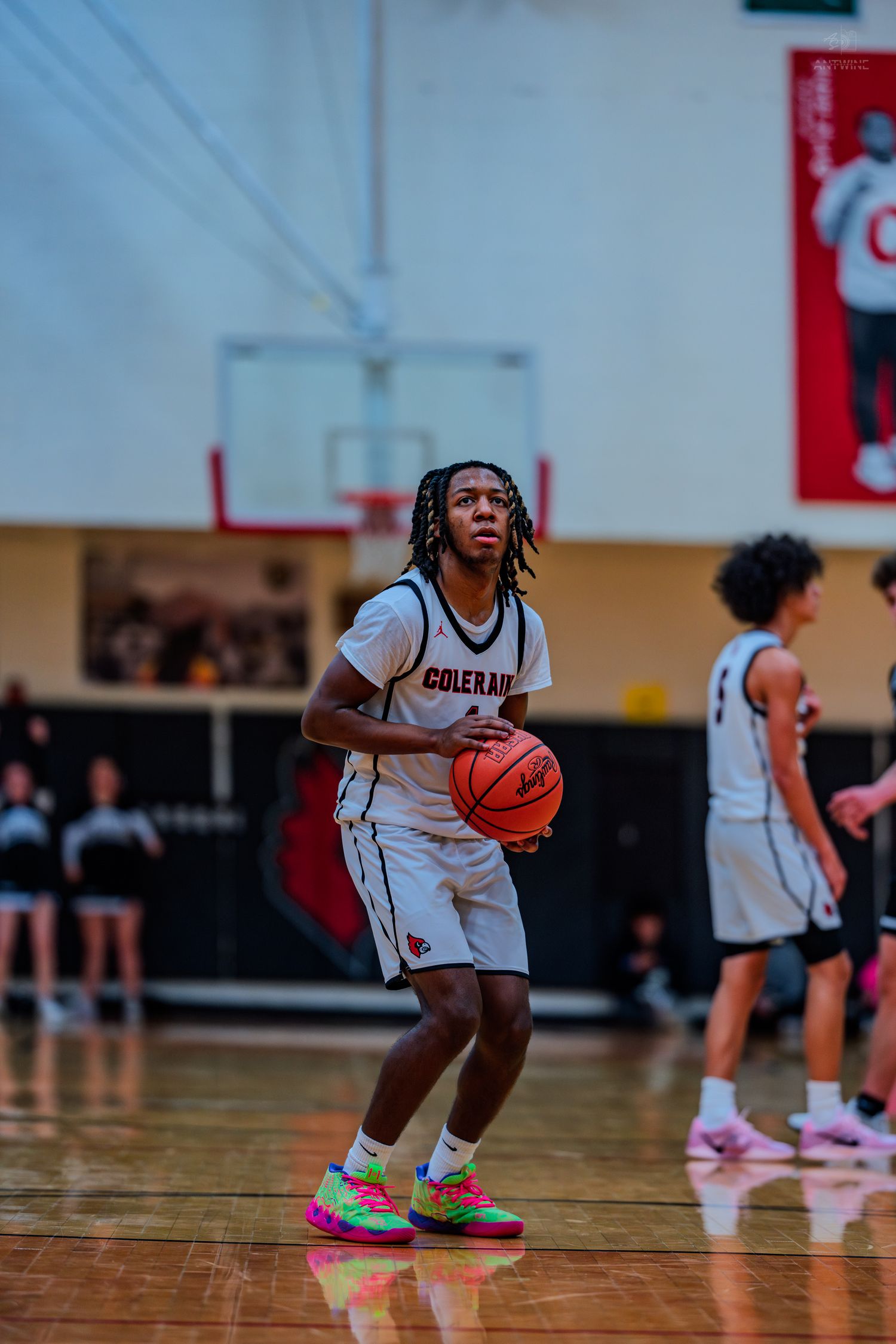 Colerain High School basketball player #1 prepares to shoot free throw in white uniform with colorful sneakers.