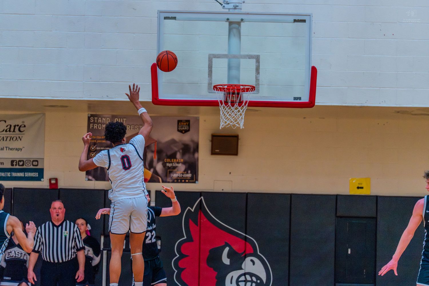 Lakota East #0 attempts a jump shot toward the basket during a high school basketball game.