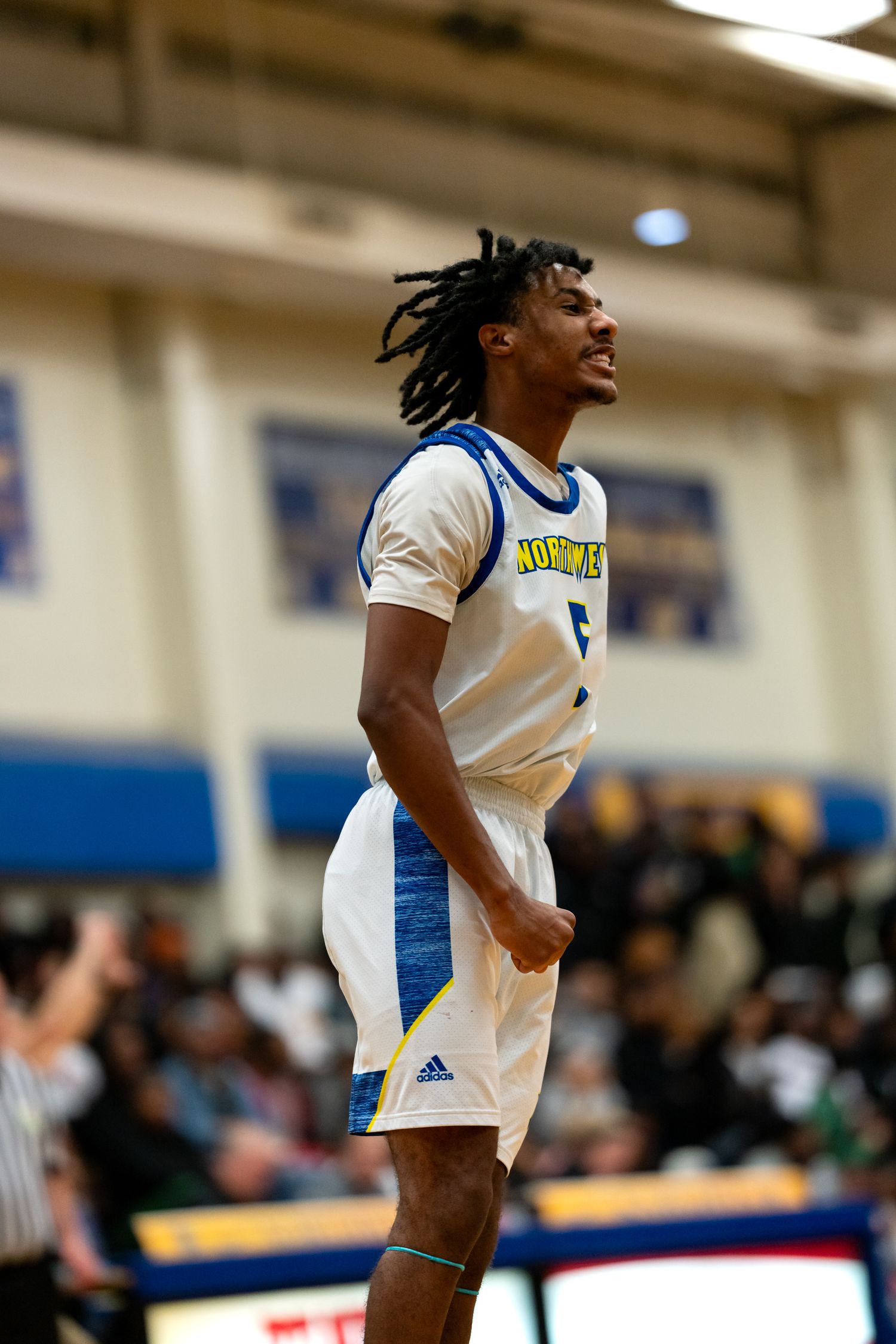 Northmen basketball player #5 celebrates with fist pump after big play during high school game.