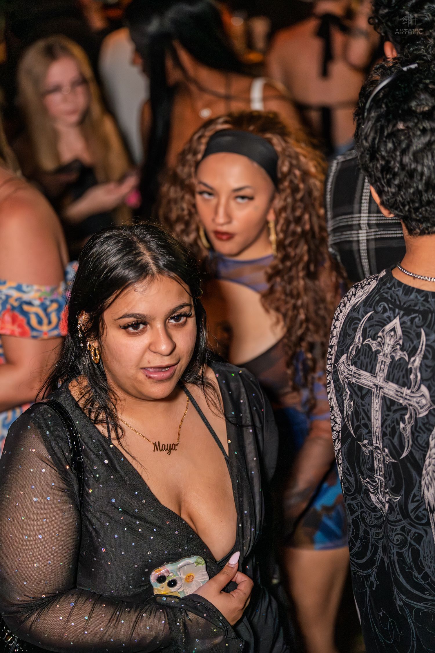 Women socializing at a crowded nightclub party event.