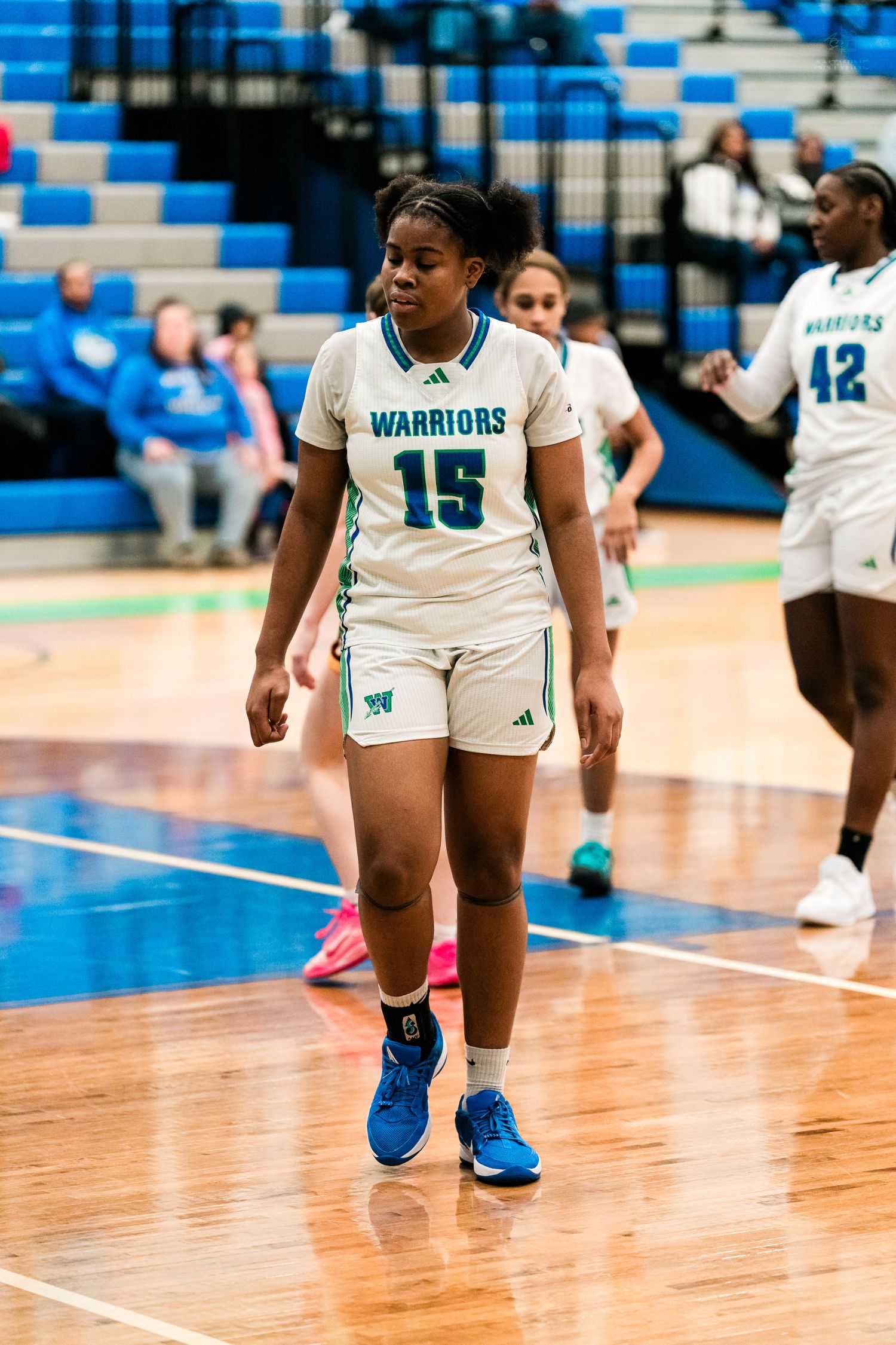 Warriors girls basketball player #15 walks on the court during a home game against Turpin.