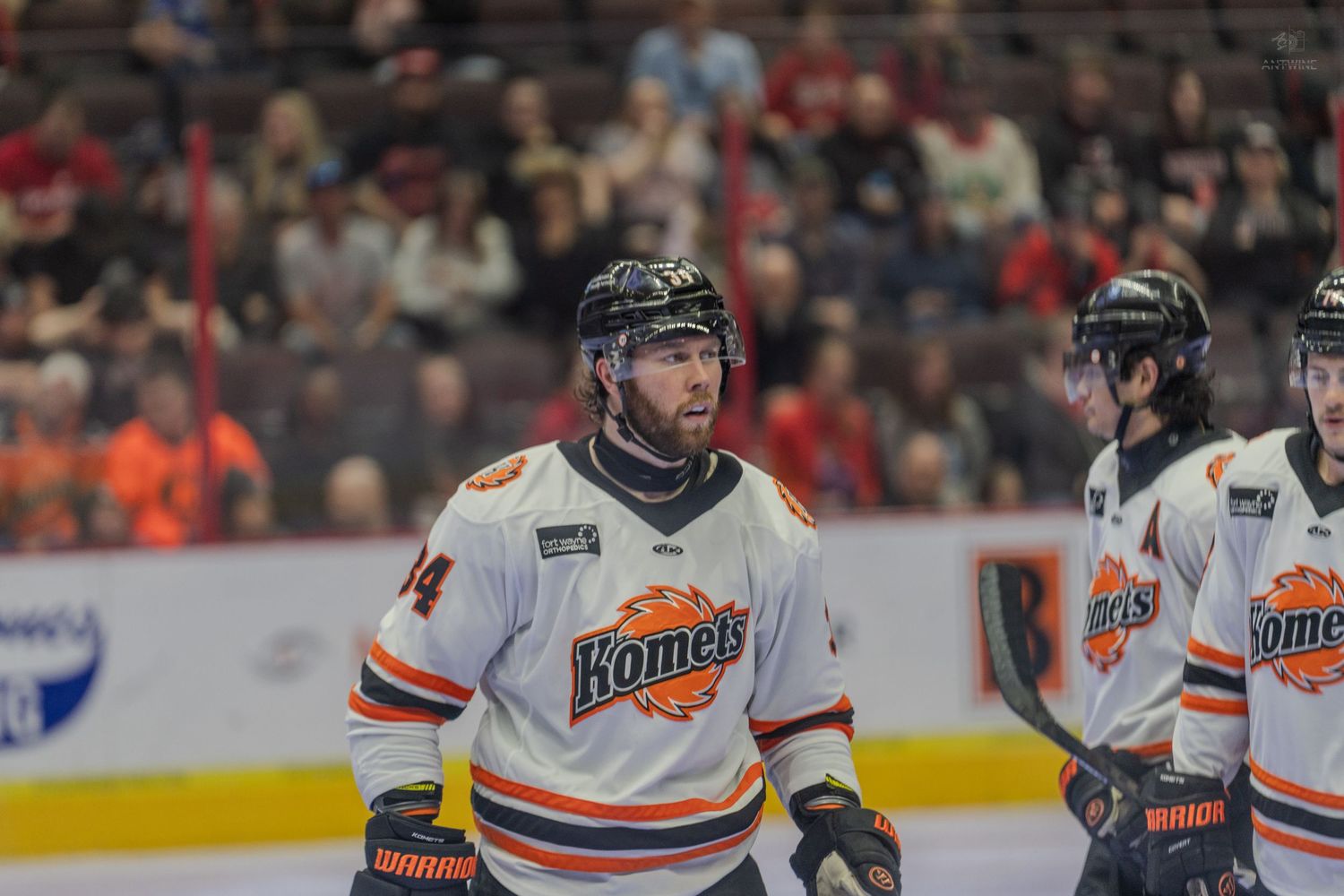 Fort Wayne Komets hockey player number 34 in white jersey stands on ice during a professional hockey game.