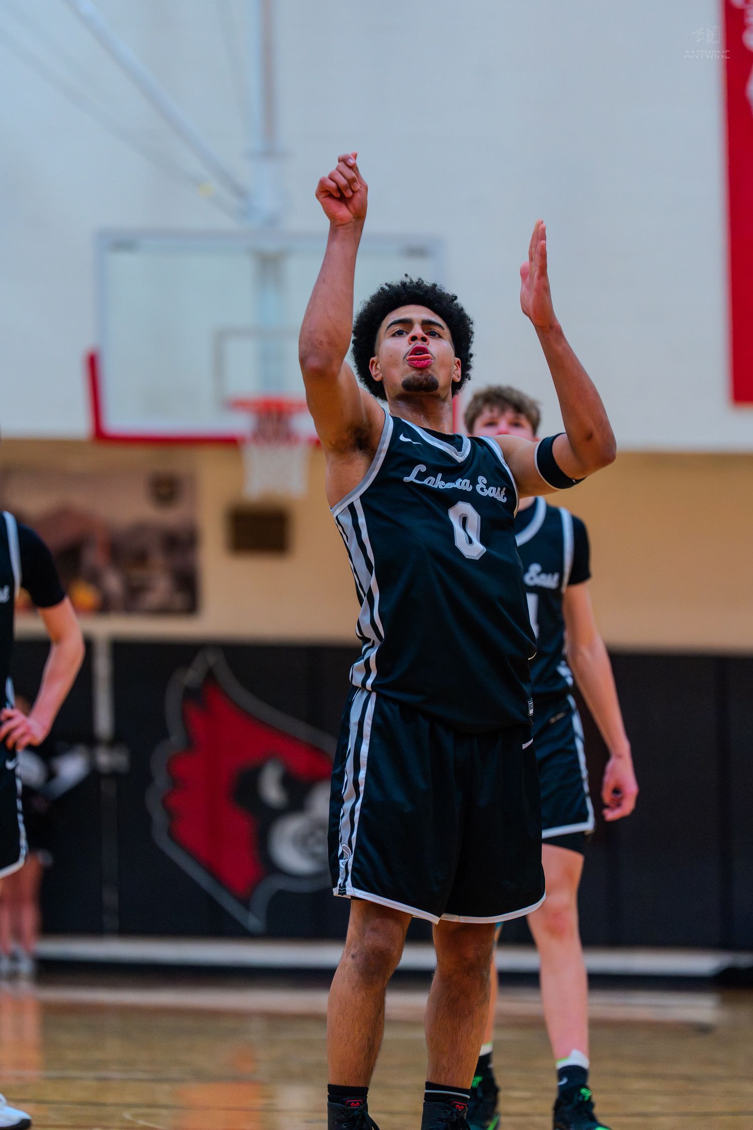 Lakota East basketball player number 0 celebrates after making a shot during a high school game.