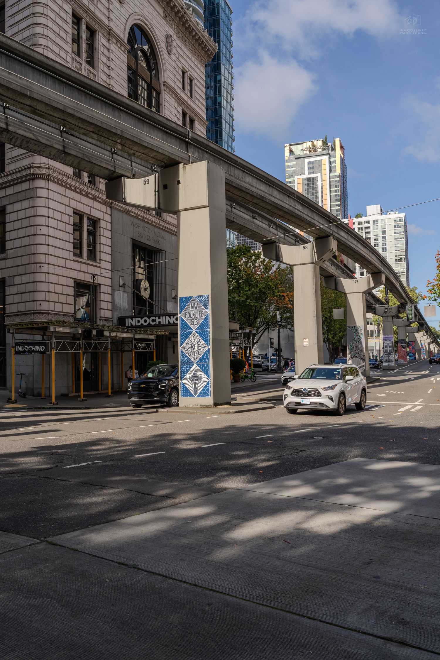 Seattle Monorail elevated track passing historic building with Indochino store at street level.