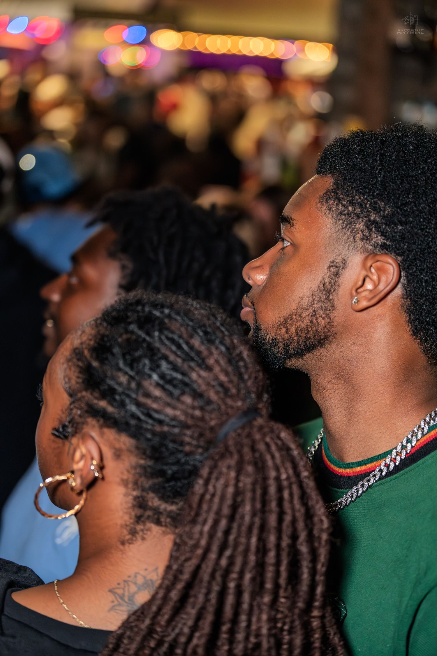 Two people looking up attentively at an outdoor nighttime event.