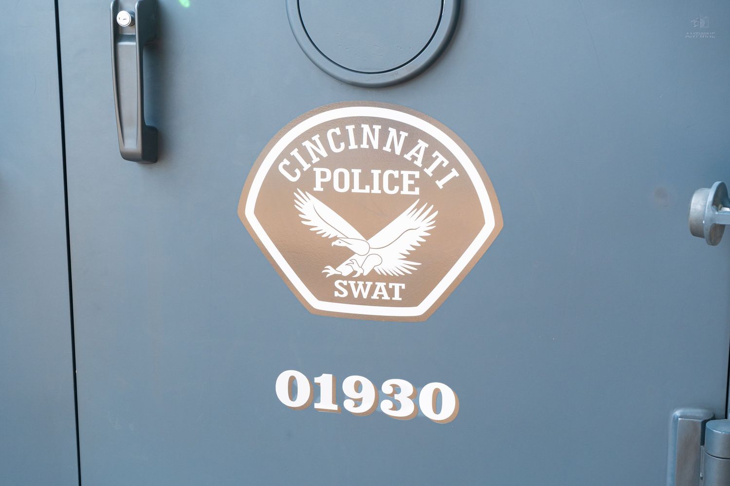 Cincinnati Police SWAT vehicle door with badge logo and unit number 01930 on gray armored truck.