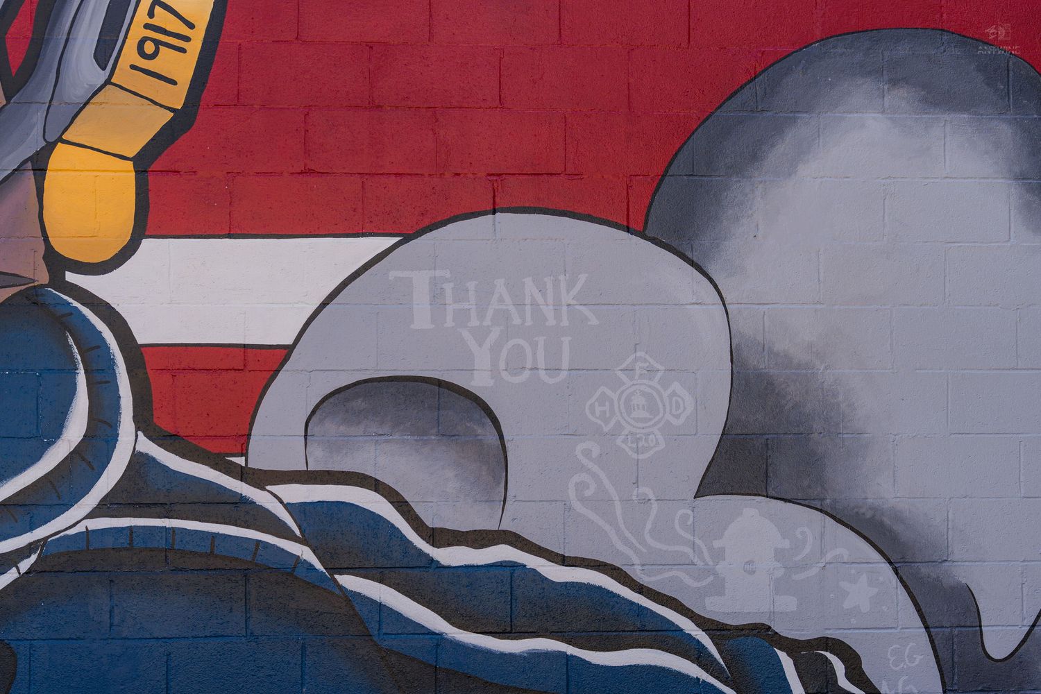 Colorful brick wall mural featuring red, blue, and gray tones with a 