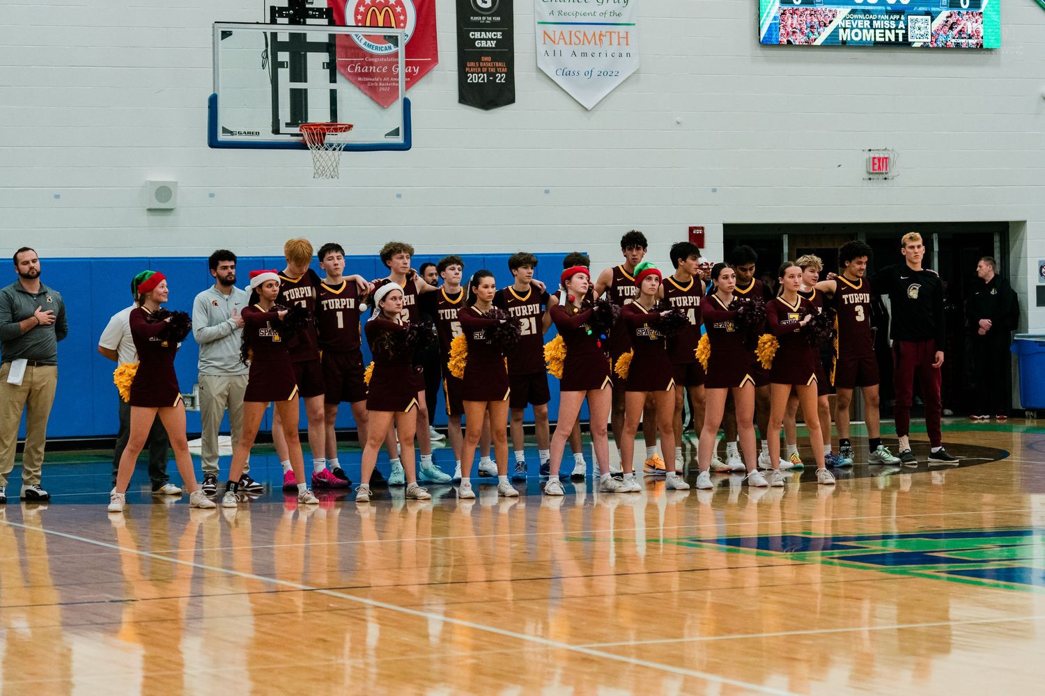 Turpin high school basketball team lined up together on court before game.