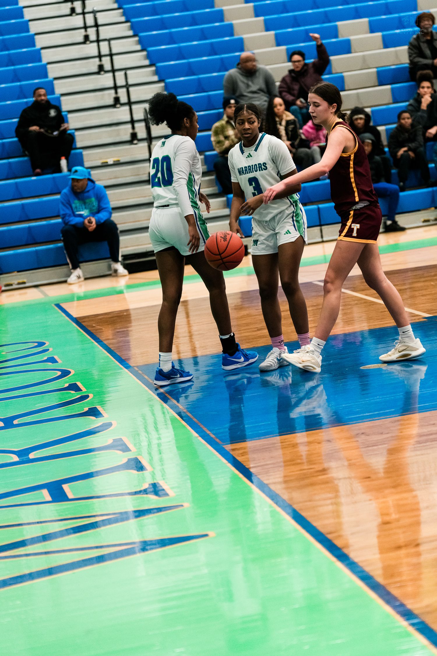 Two Harbors players #20 and #3 set up a play while Turpin defender guards in girls basketball game.