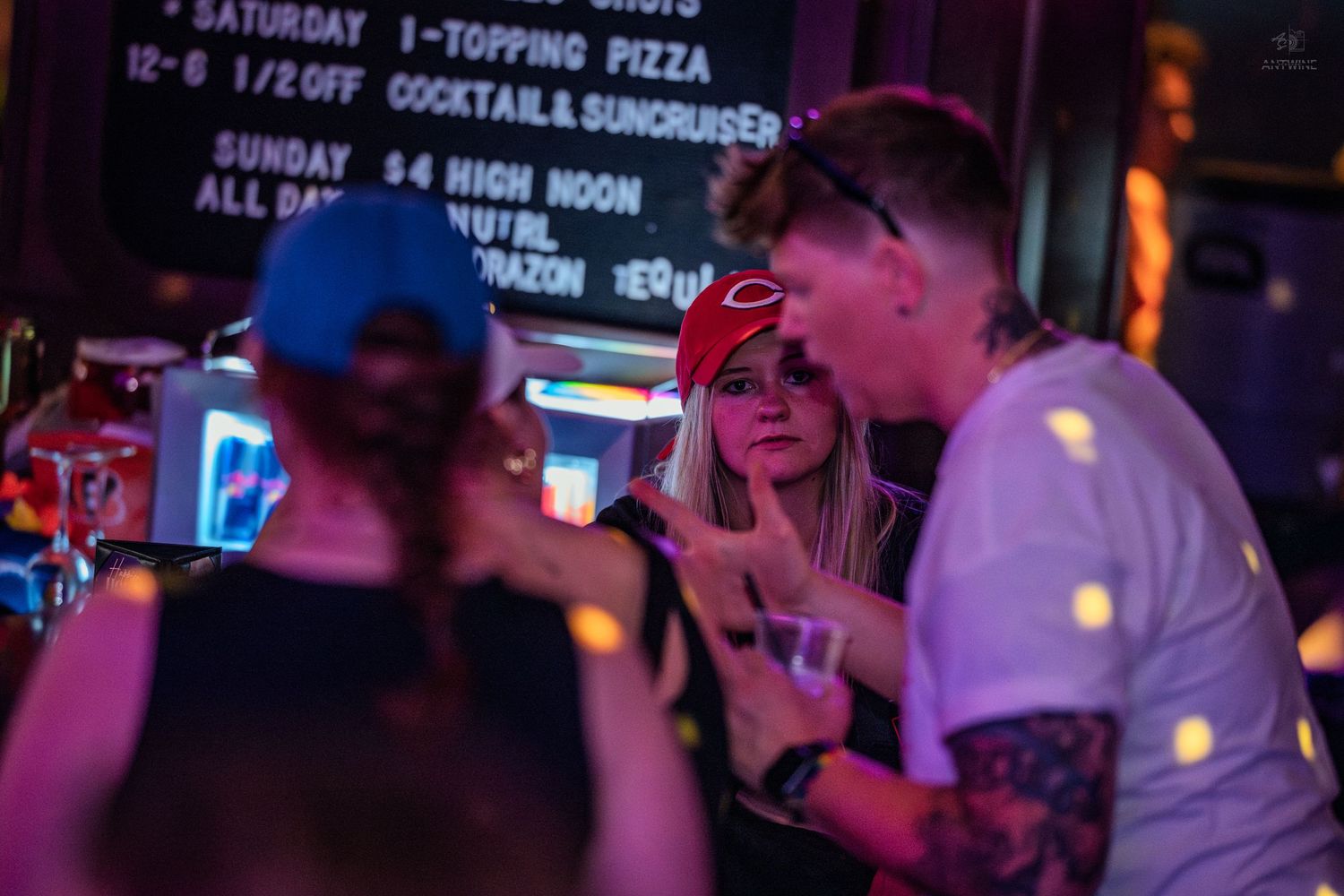 Group of friends socializing and laughing together at a lively nightclub bar.
