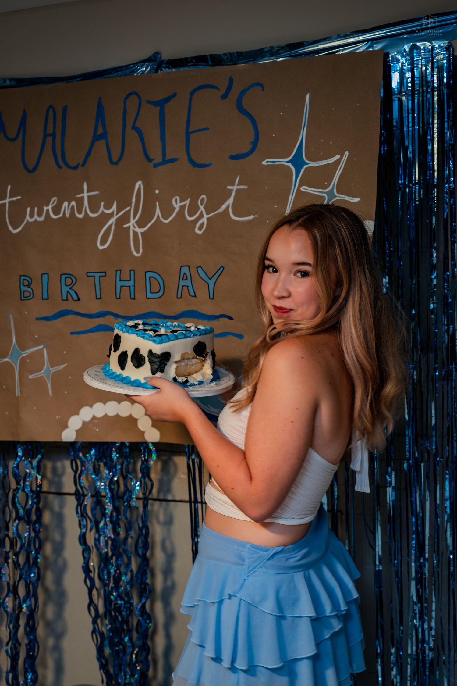Young woman poses with heart-shaped birthday cake at Malarie's twenty-first birthday celebration.
