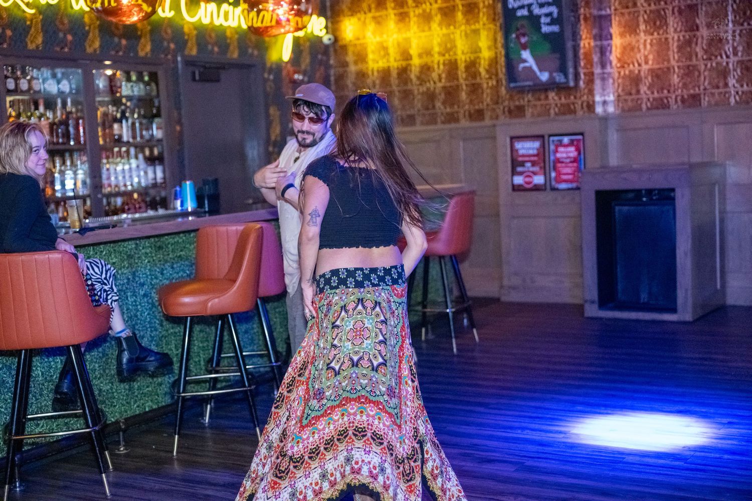 Couple dancing together on dance floor inside a warmly lit bar and restaurant venue.