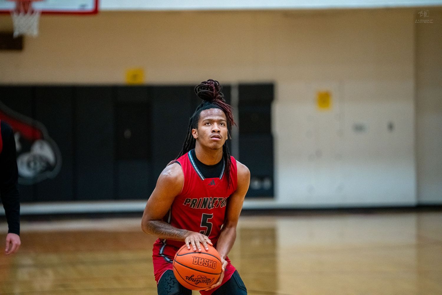 Young basketball player wearing number 5 prepares to shoot a free throw during a high school game.