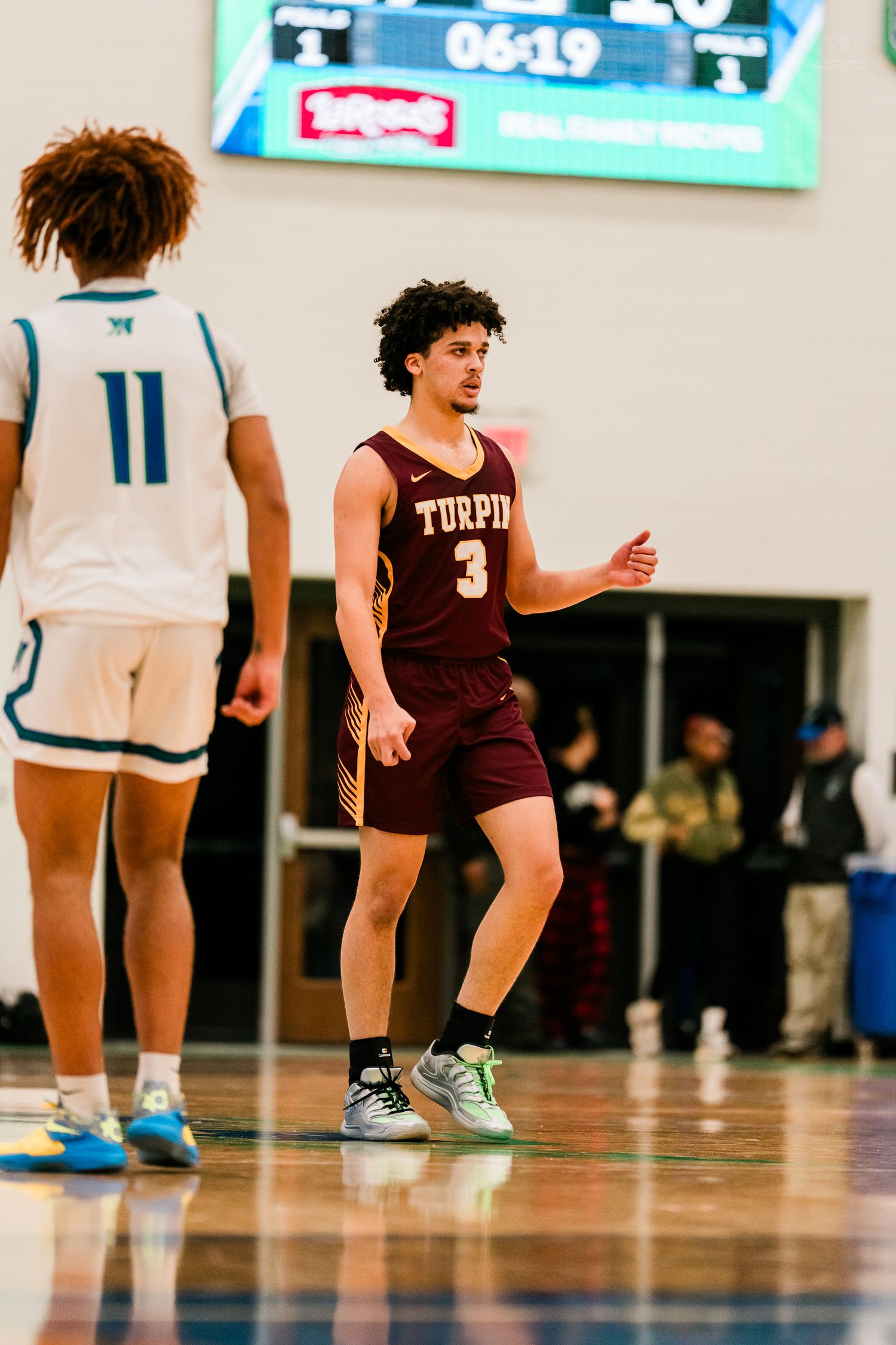 Turpin High School number 3 player gestures on court during game with scoreboard showing 6:19 remaining.
