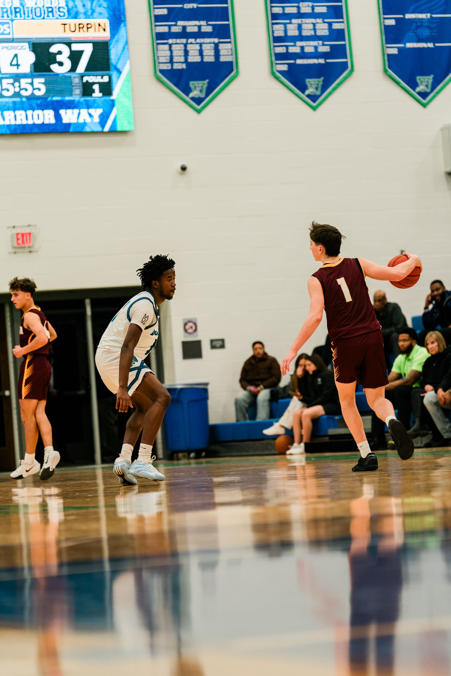 Turpin High School player #1 handles the ball while defended by a Winton Woods Warriors player.